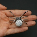 Silver spider pendant with white marble-textured stone held in hand for size - 34x47mm, 14g / Howlite