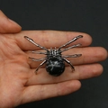 Spider pendant crafted with silver metal and a black marbled natural stone held by hand - 34x47mm, 14g / Snowflake Obsidian