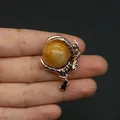 Golden dragon claw pendant holding a yellow amber bead on a necklace bail - Topaz