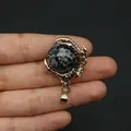 Gold plated dragon claw pendant holding a round black and white spotted natural stone orb - Snowflake Obsidian