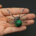 Silver spider pendant with a green malachite stone inlay held in hand for scale - 34x47mm, 14g / Malachite