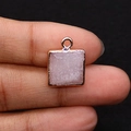Dettaglio ravvicinato del ciondolo quadrato in cristallo rosa con bordo in metallo placcato - 13x16mm / Quarzo rosa
