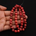 Macro view of red imperial jasper round beads with natural marble texture patterns - Red Mottled