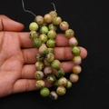 Macro view of polished round imperial jasper beads with natural green and pink texture - Green Pink Mottled (No. 19)