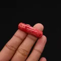 Polished red natural stone cylindrical bead for DIY jewelry being held for scale - Cylindrical Curved Style / No. 1 (Red Marbled Texture)