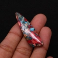Macro detail of leaf-shaped turquoise pendant with vibrant red and blue marble texture - 13x45mm / Red/Blue/Brown Intertwined