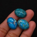 Primer plano de tres piedras de turquesa ovaladas pulidas con vetas negras en la mano - 13x18mm / N°3 (Azul Lago)