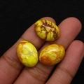 Primer plano detallado de tres cabujones ovalados de color amarillo con vetas minerales - 13x18mm / No.11 (Amarillo Brillante)