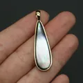 Primer plano de un colgante de gota dorado con nácar irisado en la mano - 11x40mm / Solo Colgante (Sin Cadena) - Nácar Negro