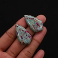 Ciondolo a goccia in pietra verde e rosa con motivi screziati tenuto da una mano - N. 13 (Mix Verde Blu Magenta)