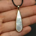 Detalle macro del colgante de nácar en forma de lágrima con borde dorado brillante - 11x40mm / Collar de Nácar Blanco