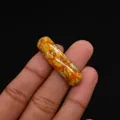 Polished tricolor emperor stone cylinder bead for DIY jewelry making shown in hand - Cylindrical Curved Style / No. 20 (Orange Yellow Green)
