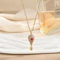 Detalle del colgante de globo aerostático dorado con corazón rojo y cristales finos - Estilo Globo Aerostático Corazón Rojo Pavé (XL02455)