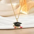 Macro-opname van vergulde afstudeerhoed ketting met rood emaille en kristallen details - Afstudeerpet Rol met Kwastje (XL02479)
