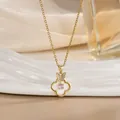 Makroaufnahme einer Goldkette mit Schmetterlings- und Kleeblattanhänger mit rosa Edelstein - Schmetterling Perlmutt Kleeblatt Stil (XL02538)