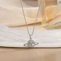 Makroaufnahme der silbernen Saturn-Halskette mit funkelnden Kristallen und Perlen-Akzent - Saturn Planet Stil (XL02540G)