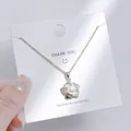 Nahaufnahme der goldenen Perlenblumen-Halskette auf einer weißen Geschenkkarte - Perlenblumenstil