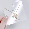 Detailaufnahme einer goldenen Schmetterling-Schlüsselkette mit rosa Herzstein auf Karte - Schleife Herz Schlüssel Stil