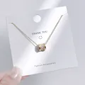 Detailansicht eines goldenen zylindrischen Anhängers mit funkelnden weißen Zirkonia-Steinen - Zylindrischer Pave-Strass-Stil