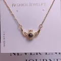 Detail of gold wing pendant necklace with central round bead on fashion jewelry card - Angel Wings Style (TY0036) / Gold