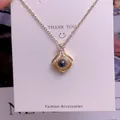 Detailaufnahme einer Goldkette mit Projektionsanhänger, schwarzem Stein und Kristallen - Geometrisches Design(TY0074)