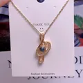 Detailed close-up of golden treble clef pendant necklace with zircon and projection stone - Treble Clef Style (TY0045) / Gold