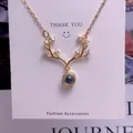 Detail of gold reindeer antler pendant with small white zircons and a grey projection stone - Antler Shape (TY0046) / Gold