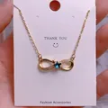Detail of infinity pendant necklace with blue star gem and zirconia on gold chain - Blue Star Infinity Style (SQ005)