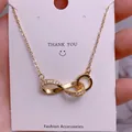 Detailed macro view of the gold infinity pendant with white sparkling zircon stones - Pave Rhinestone Infinity Style (SQ006)