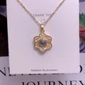 Makroaufnahme einer goldenen Blumenkette mit Projektionsstein und Kristallblüten - Sechsblättrige Blume Design(TY0078)