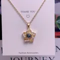 Detailed macro view of a gold flower pendant necklace with 100 languages projection stone - Flower Style (TY0052) / Gold