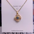 Detail of gold pendant necklace with square zircon border on a white display card - Square Round Style (TY0054) / Gold