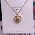 Macro shot of gold heart pendant with gray projection stone on a white display card - Spiral Heart Shape (TY0057) / Gold