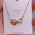 Macro shot of gold infinity necklace with red enamel hearts and sparkling zircon details - Double Red Hearts Infinity Style (SQ0017)