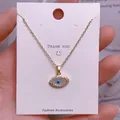 Makroaufnahme des goldenen Evil Eye Anhängers mit blauem Emaille und Kristalldetails - Goldener Augenumriss Mikro-Strassanhänger (YJ0013)