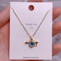 Detaillierte Nahaufnahme der goldenen Evil Eye Halskette mit blauem Anhänger auf Karte - Goldener Hörner-Böses-Auge-Anhänger (YJ0014)