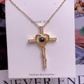 Makroaufnahme von Goldkreuz und Herzanhänger mit Projektionsstein und Zirkonia-Details - Kreuz Herz Design(TY0095)