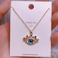Detaillierte Makroansicht des goldenen Evil Eye Anhängers mit bunten Kristallen und blauem Stein - Goldener Augenwimper-Mehrfarben-Strassanhänger (YJ0025)