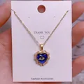 Detailaufnahme der herzförmigen Evil-Eye-Halskette mit funkelnden weißen Zirkonia-Steinen - Goldener Herz-Blauer-Böses-Auge-Strassanhänger (YJ0028)