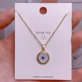 Makroaufnahme der goldenen Teufelsauge-Halskette auf einer Dankeskarte aus Schmuck - Goldener Runder Böses-Auge-Anhänger Mit Gedrehtem Rand (YJ0036)