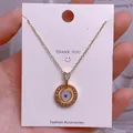 Detailaufnahme der goldenen Evil Eye Halskette mit Love-Gravur auf eleganter Displaykarte - Goldener Dreischichtiger Konzentrischer LOVE-Augenanhänger (YJ0041)