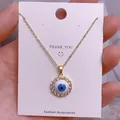 Detailaufnahme der Evil Eye Halskette mit blauem Stein und weißen Kristallen - Goldener Runder Mikro-Strass Augenanhänger (YJ0044)