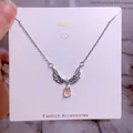 Collier ailes d'ange en acier titane avec zircon et pierre goutte d'eau irisante - Style Argent Ailes Pierre de Lune Artificielle Goutte (CB07)