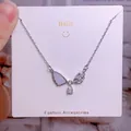 Collier aile de cœur en titane avec émail bleu et cristaux de zircone cubique étincelants - Style Strass Bleu Clair Ailes de Papillon Asymétriques (CB13)