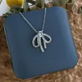 Détail macro du pendentif nœud argenté avec cristal sur un écrin à bijoux - Zirconia Rectangulaire Nœud Argent (XL0611G)