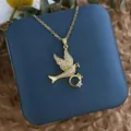 Détail du collier hirondelle plaqué or avec zircons sur un écrin à bijoux bleu - Anneau d'Oiseau Or (XL0612)