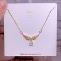Collier en acier titane doré avec ailes serties de diamants et pendentif en goutte - Style Pierre Claire Goutte Ailes Ajourées (CB18)