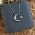 Détail du collier pendentif étoile et lune plaqué or avec zircons sur une boîte à bijoux - Étoile Lune Imbriquée Argent (XL0616G)