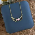 Détail d'un pendentif ailé plaqué or avec un cœur rose et des pierres en zircone - Cœur d'Aile Zirconia Rose Or (XL0609A)