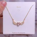 Collier avec cristal de cœur rose et ailes dorées présenté sur une carte d'accessoires - Style Ailes Pierre Cœur Rose Or (CB30)